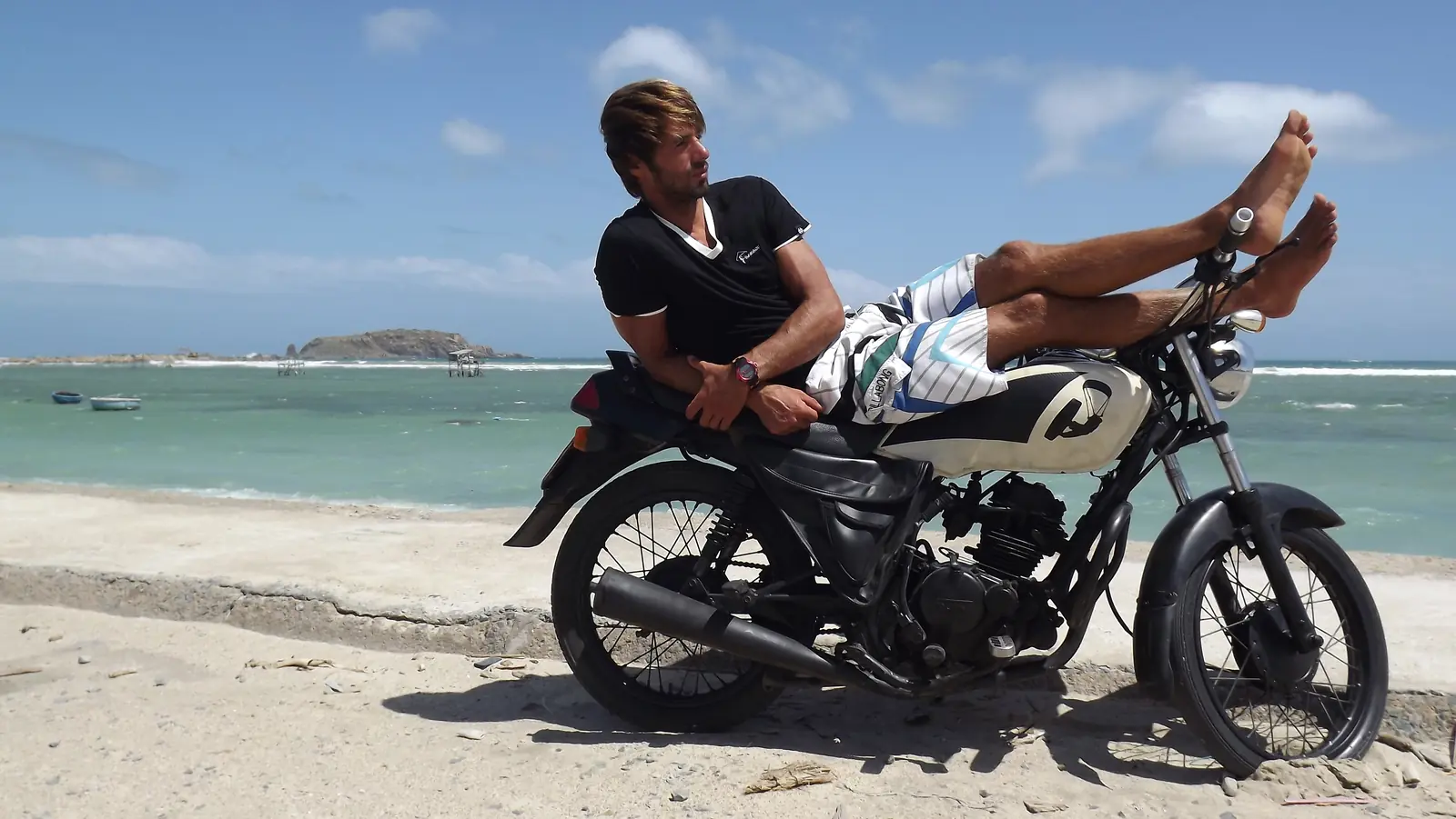 Viktor lying on a motorbike near the beach